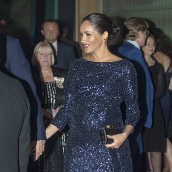 Meghan Markle também não deixou os metalizados de lado: em teatro com o marido, brilhou em um longo azul com brilho