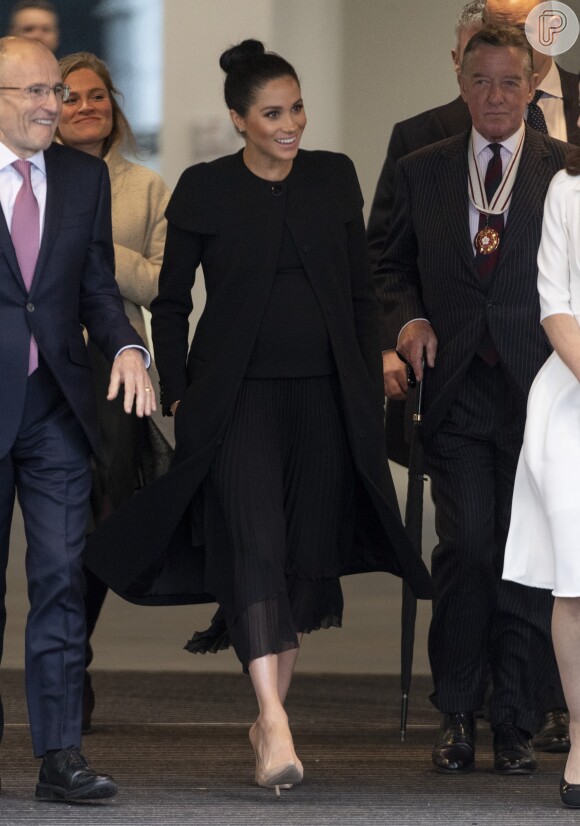 Meghan Markle escolheu trench coat Givenchy e vestido no mesmo tom para evento no trimestre final da gravidez