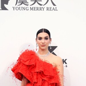 Dua Lipa com risca central bem marcada e wet hair para deixar look e acessórios brilharem