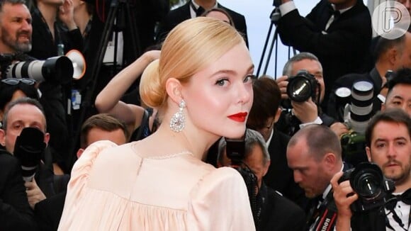 Coque baixo e volumoso de Elle Fanning combina com acessórios grandes e looks com bastante informação