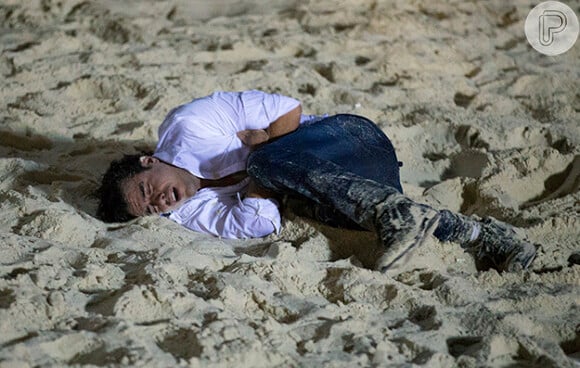 Após o surto, Enrico (Joaquim Lopes) se encolhe na areia, em 'Império'