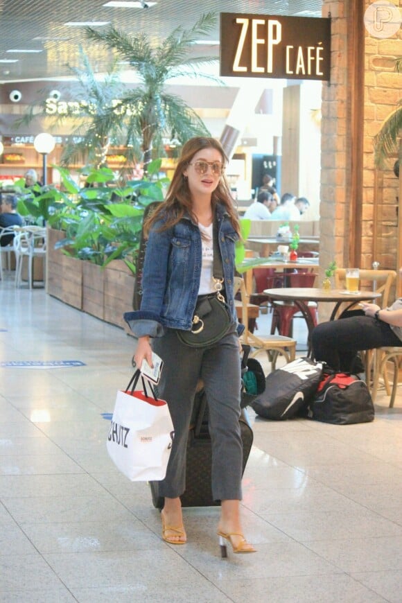 Marina Ruy Barbosa usou jaqueta jeans, calça de alfaiataria e sandálias nude para embarcar em aeroporto do Rio