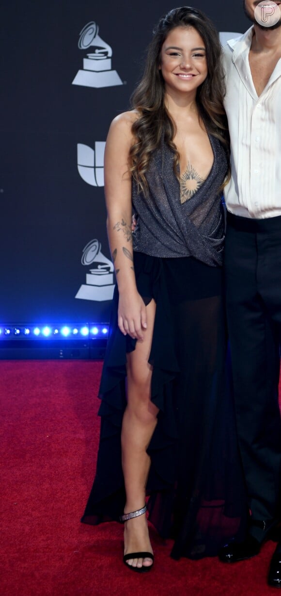 Namorada de Tiago Iorc aposta em blusa prateada de decote profundo e saia com transparência e fenda no Grammy Latino nesta quinta-feira, dia 14 de novembro de 2019