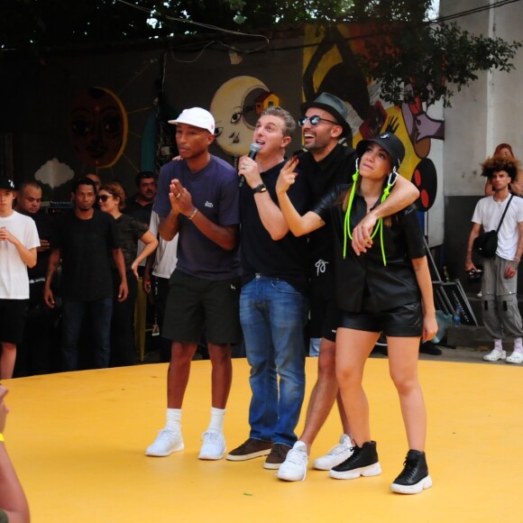 Anitta, com chapéu curioso, dança comendo açaí ao visitar comunidade. Fotos!