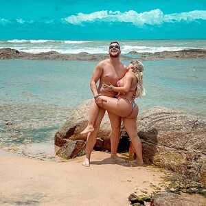 Zé Neto e mulher, Natália Toscano, posaram abraçados em praia da Bahia