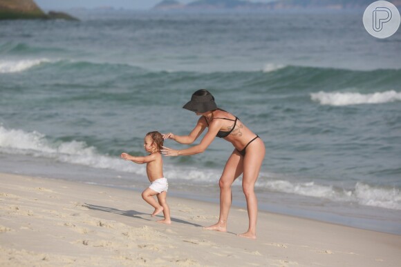 Isis Valverde arruma cabelo do filho, Rael, em praia da Barra da Tijuca