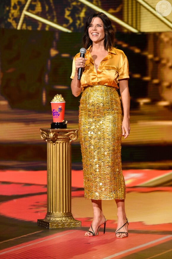 Neve Campbell aposta em camiseta de seda e saia de paetê da marca Aliette no MTV Movie & TV Awards!