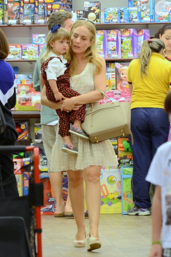 Angélica segura a filha, Eva, de 2 aninhos, no colo durante vista a loja de brinquedos no Rio