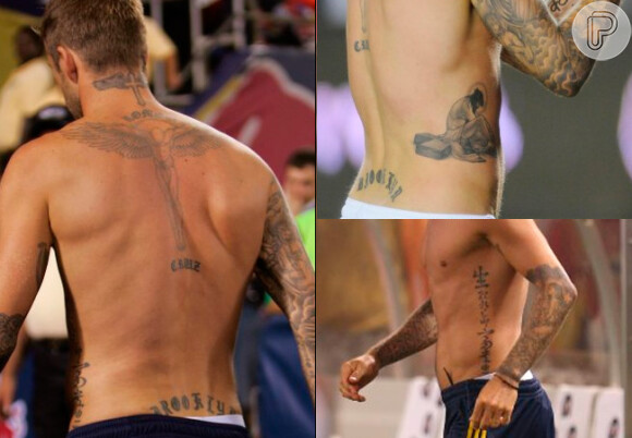O jogador David Beckham tem os braços fechados por desenhos e um anjo nas costas