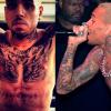 Chris Brown tem os braços fechados e parte do peito por tatuagens