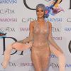Para receber o título de ícone da moda, Rihanna ousou muito em um vestido de brilhantes e transparente, que deixou a lingerie e os seios à mostra