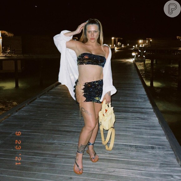 Cleo usa saia com recorte lateral para jantar em destino de praia
