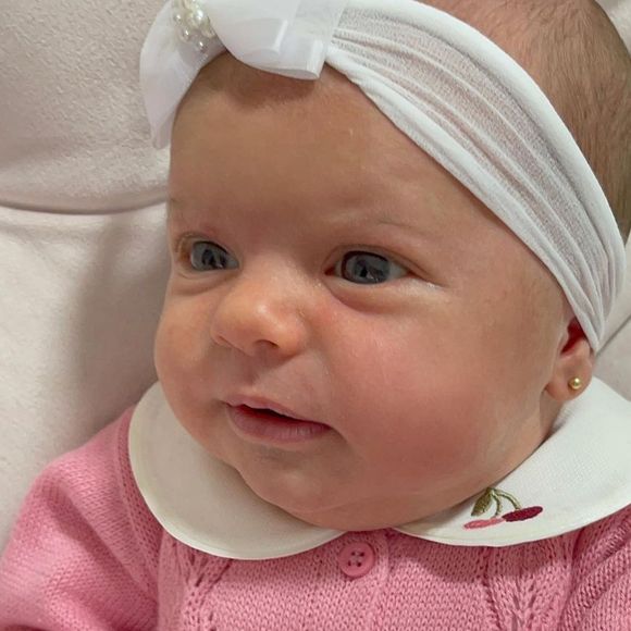 Filha caçula de Thaeme Mariôto usou roupa rosa, combinando com um laço branco