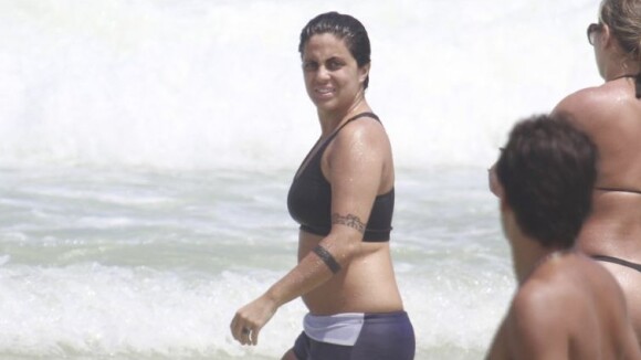 Thammy Miranda, de top e sunga, curte praia do Rio e se refresca com amigas