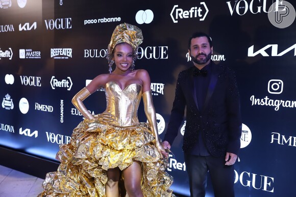 Thelminha Assis chega com o marido com um look todo dourado para Baile da Vogue