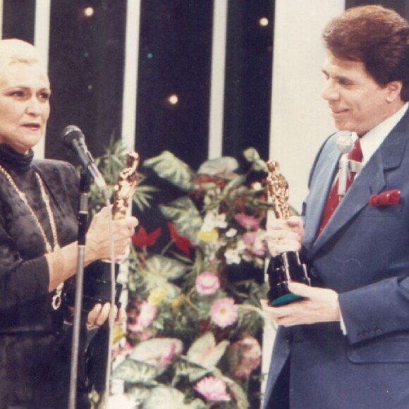 Silvio Santos (José Rubens Chachá) é surpreendido por Hebe Camargo (Martha Mellinger) na série 'O Rei da TV' em seu programa; na realidade, o dono do SBT chamou a apresentadora ao palco de sua atração em 21 de fevereiro de 1988