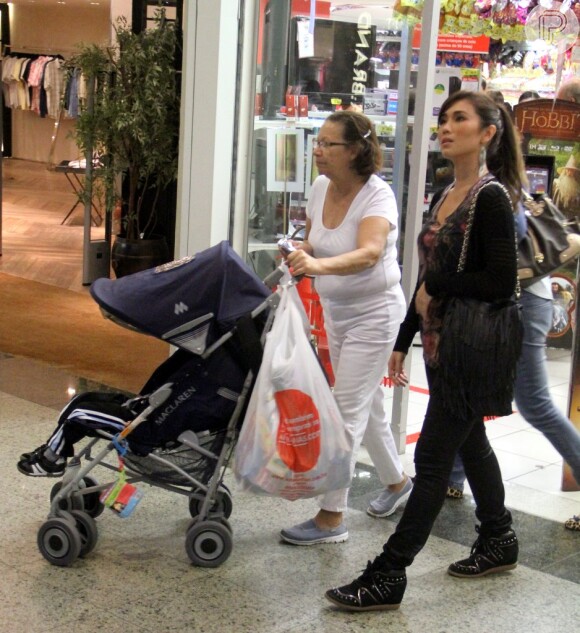 Daniele Suzuki sai da loja com babá, que empurra carrinho de bebê com Kauai dentro