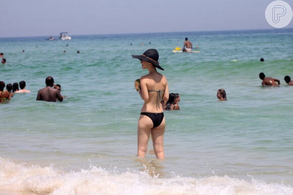 Nathalia Dill usou biquíni comportado e um enorme chapéu em ida à praia