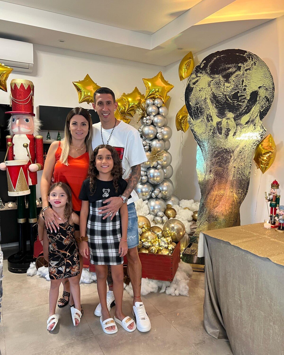 Foto: Di Maria, jogador da Seleção Argentina, posa com a mulher e as filhas  e exibe a decoração com a taça ao fundo em homenagem à Copa do Mundo  conquistada - Purepeople