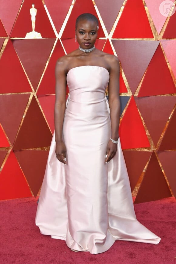 A atriz Danai Gurira da Marvel foi a cerimênia do Oscar com este vestido longo rosa claro. 