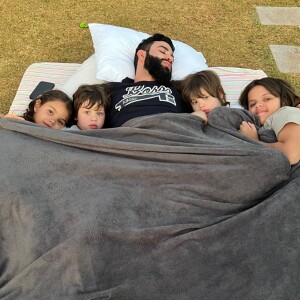 Gusttavo Lima apareceu em foto dormindo com os filhos e outras crianças da família em um jardim