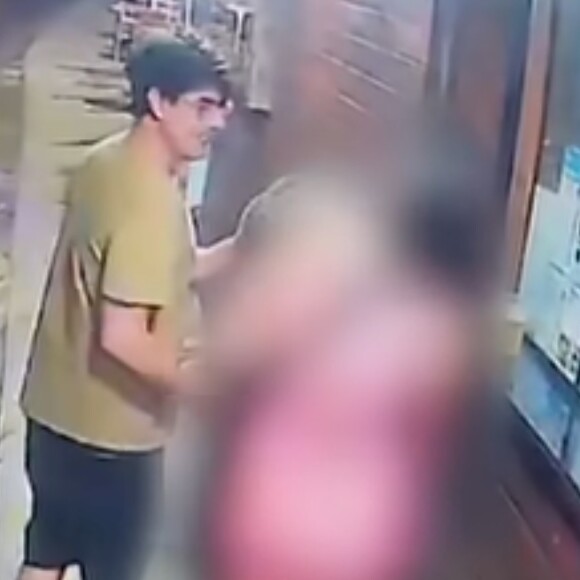Kayky Brito tenta beijar, no rosto, mulher em quiosque da Barra da Tijuca, enquanto Bruno de Luca faz de tudo para separar o ator