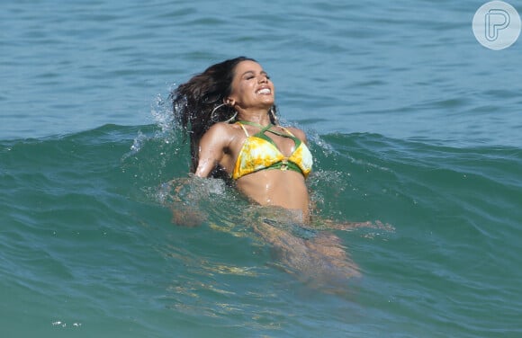 Anitta também foi flagrada em cenas divertidas, como esta sendo levada pelas ondas do mar