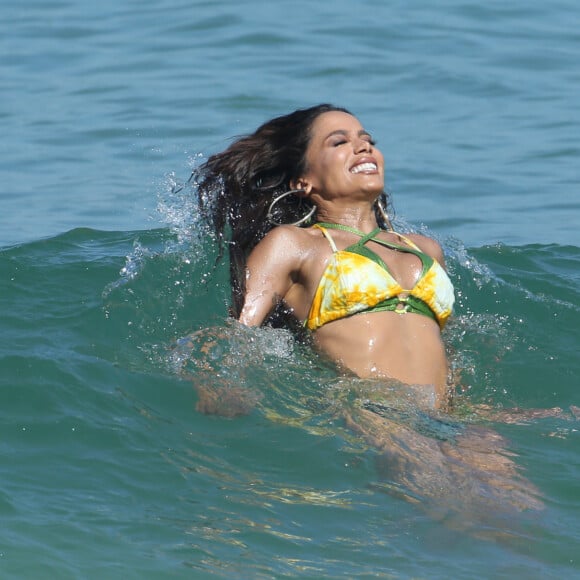 Anitta também foi flagrada em cenas divertidas, como esta sendo levada pelas ondas do mar