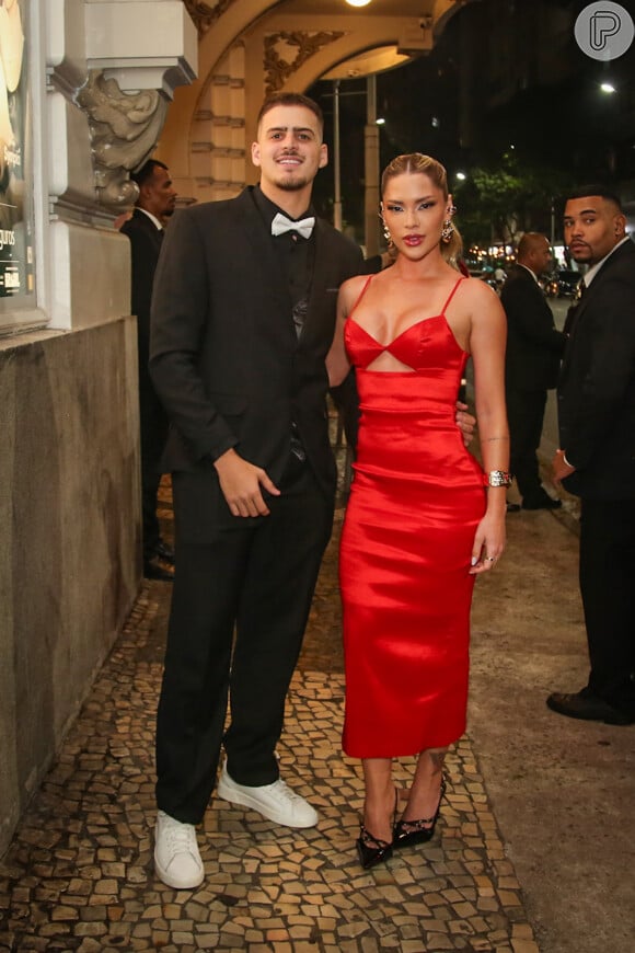 Vestido vermelho com decote foi opção da influencer Mayara Maia, ao lado do youtuber Jon Vlogs