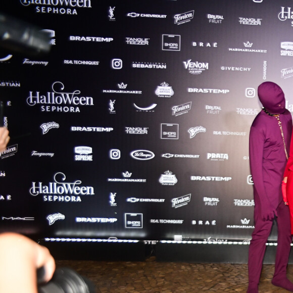 Flávia Alessandra  investiu em um look todo vermelho, composto por terninho, saia coladinha ao corpo na altura dos joelhos, chapéu, luvas e, claro, muitas joias!