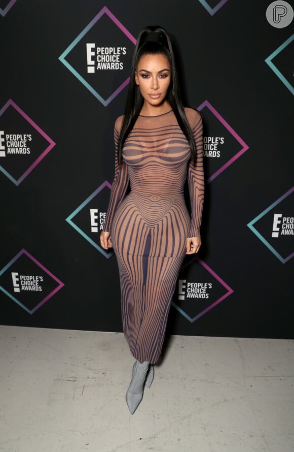 Kim Kardashian usou a versão high-fashion do vestido transparente, cujas linhas azul-marinho dominavam seu corpo e destacavam barriga e as coxas, pelo People's Choice Awards, em novembro de 2018.