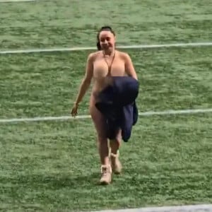 Enquanto o Toronto Argonauts e o Winnipeg Blue Bombers lutavam na final da liga, os jogadores ficaram surpresos quando a mulher - que usava apenas botas marrons e segurava um casaco azul - interrompeu a partida em Vancouver.