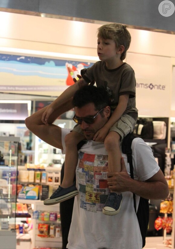 Thiago Lacerda leva o filho, Gael, nos ombros, momentos antes de embarcarem, em 30 de novembro de 2012