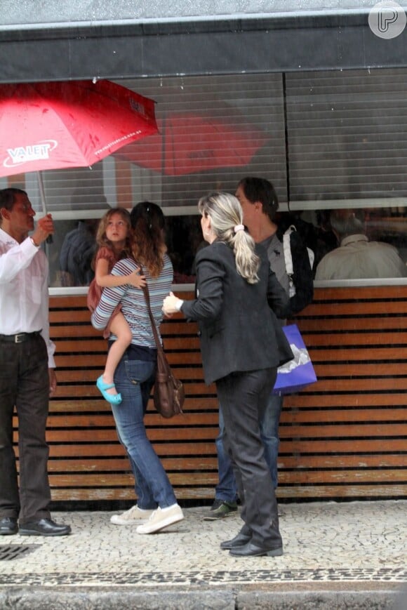 Pedro Cardoso acompanha a mulher, Graziella Moretto, que segura a filha do casal no colo na saída de restaurante no Leblon, no Rio