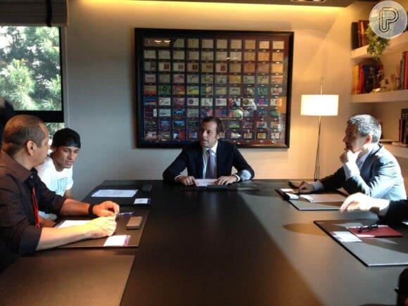 Neymar assina o contrato com o novo clube ao lado do pai, em 3 de junho de 2013. Sandro Rosell, Presidente do FC Barcelona, no ato da assinatura do contrato