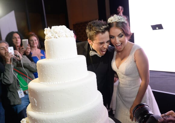 Os noivos DH Silveira e Bruna Unzueta fizeram caretas para as câmeras junto à mesa do bolo