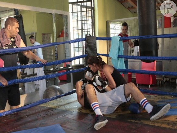 Ao perceber que machucou Grego, Mari coloca gelo no nariz do rapaz e é surpreendida com um beijo roubado