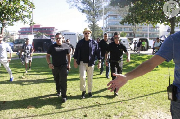 John Travolta é acompanhado por seguranças nas gravações do comercial