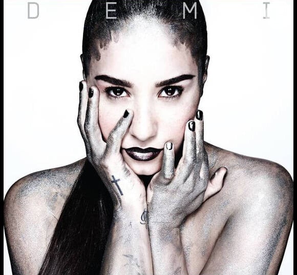 Demi Lovato aparece nua e coberta por uma poeira escura na capa do disco que leva seu nome