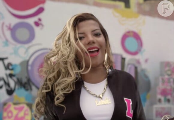 No clipe da faixa 'Te Ensinei Certin', Ludmilla paarece com jaqueta e cordão personalizados e cabelos mais longos e loiros