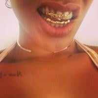 Rihanna coloca acessório dentário de ouro em forma de arma