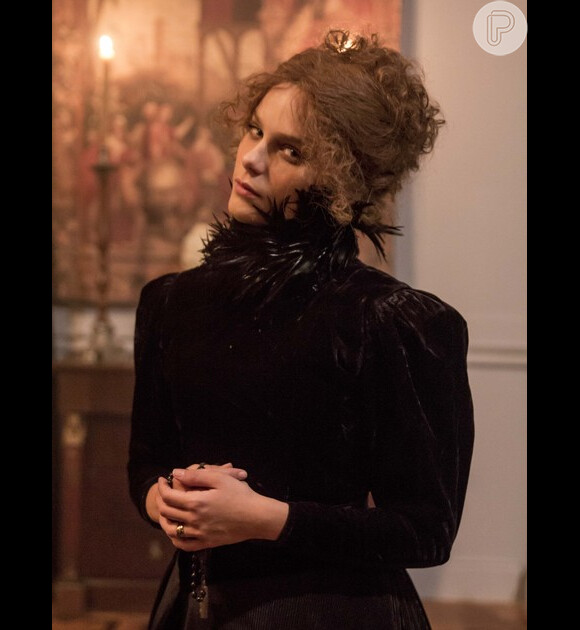 Vestido usado por Isabella Santoni em 'Ligações Perigosas' é um longo preto rodado e acinturado, com detalhes em seda e veludo, e penas por toda a gola