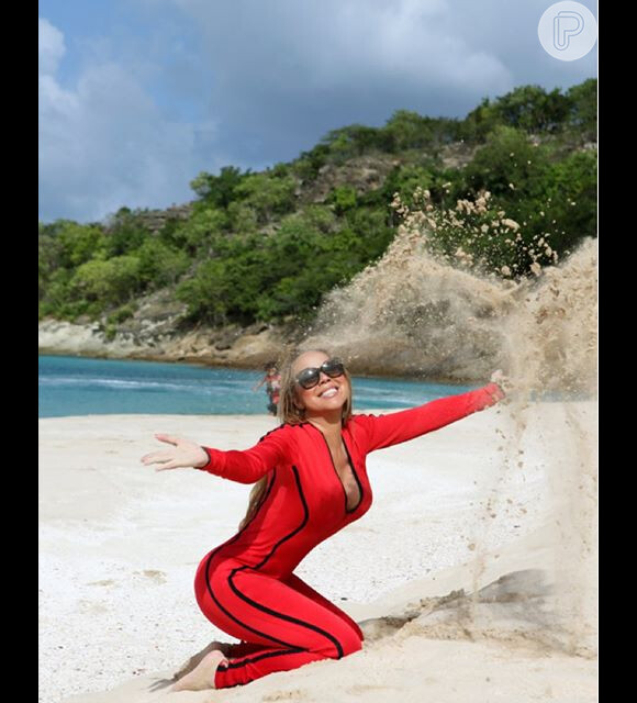 Mariah Carey brinca com areia enquanto é clicada na praia