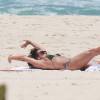 Luiza Brunet se espreguiça durante banho de sol na Praia da Reserva, na Barra da Tijuca