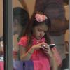 Katie Holmes brinca no celular dentro de uma padaria em Nova York