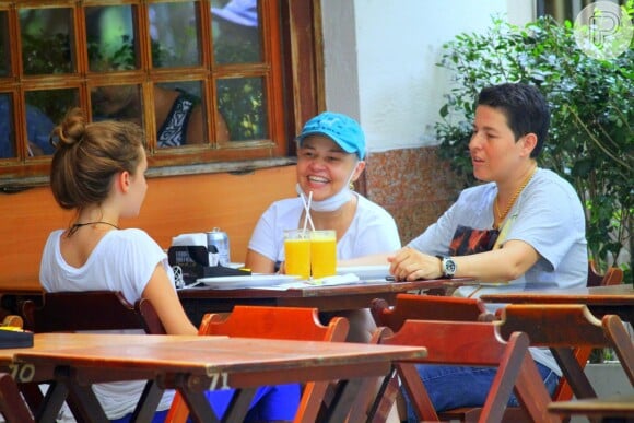 Claudia Rodrigues sorri em restaurante com Isa, de 13 anos, e a empresária, Adriane Bonatto
