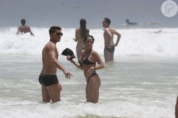 Danielle Winits toma banho de mar com o namorado