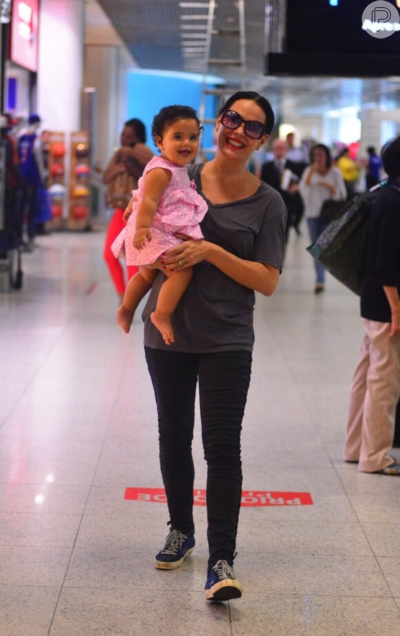 Filha mais nova de Carolina Ferraz, Anna Izabel, de 10 meses, esbanjou fofura com vestidinho rosa e os pés descalços em aeroporto do Rio