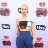Iggy Azalea apostou em calça azul de cintura alta e top cropped no tapete vermelho do iHeartRadio Music Awards, neste domingo, 3 de abril de 2016
