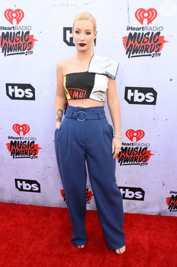 Iggy Azalea apostou em calça azul de cintura alta e top cropped no tapete vermelho do iHeartRadio Music Awards, neste domingo, 3 de abril de 2016